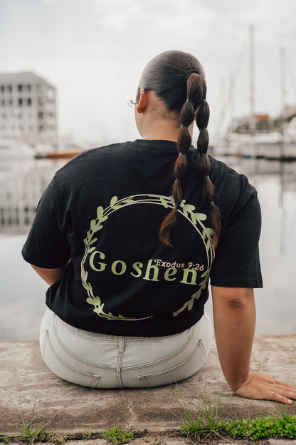 Woman wearing black Goshen t-shirt - back